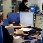 Employée d'une CPAM devant son bureau