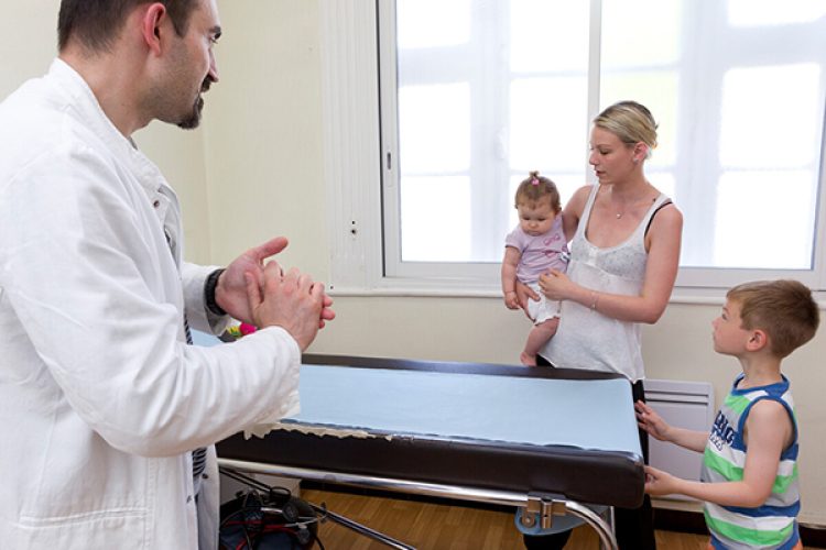 Medecin generaliste au cabinet medical. Medecin discutant avec les parents d un enfant malade.